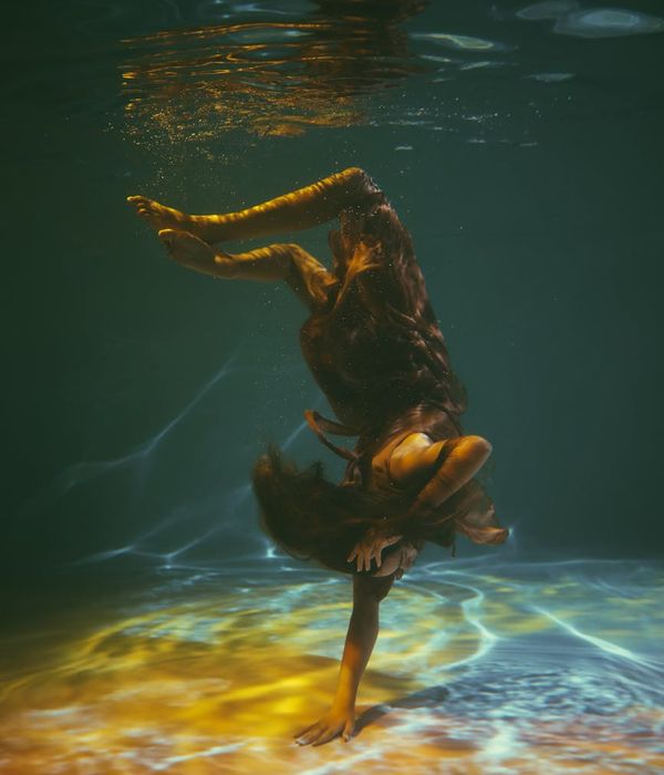 Woman performing a fluid, low-impact cardio movement in a bright, airy room.